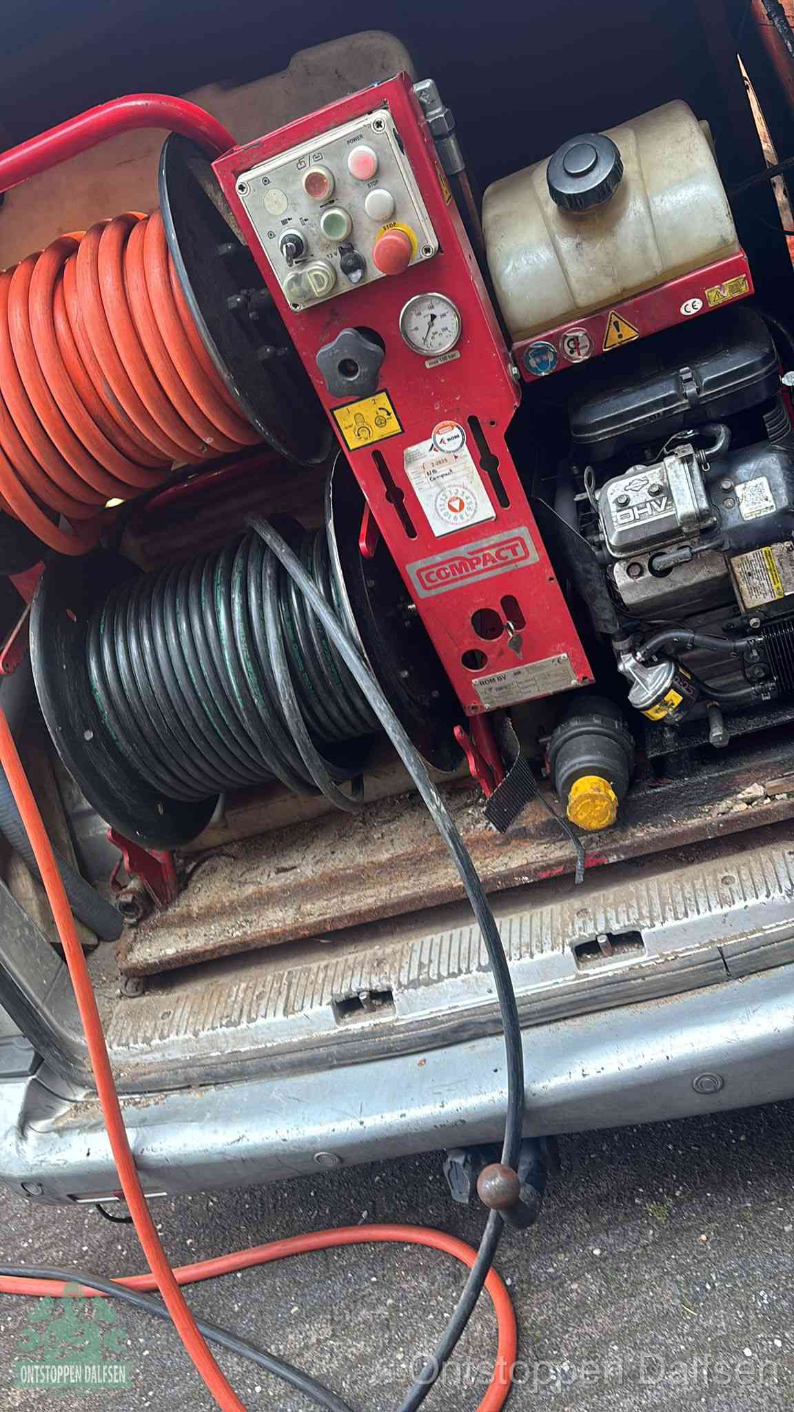Een rood hogedruk-rioolreinigingstoestel in de laadbak van de bedrijfsbus, apparatuur voor een hardnekkige afvoerverstopping in Dalfsen