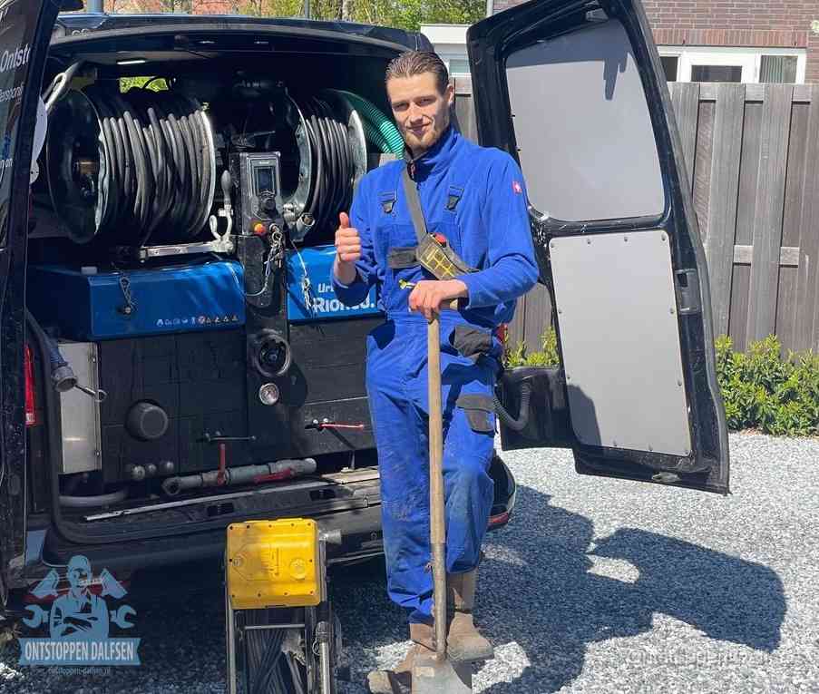 Een monteur bij de werkbus met grote hogedruk-slanghaspels, apparatuur voor hardnekkige afvoerverstoppingen in Dalfsen
