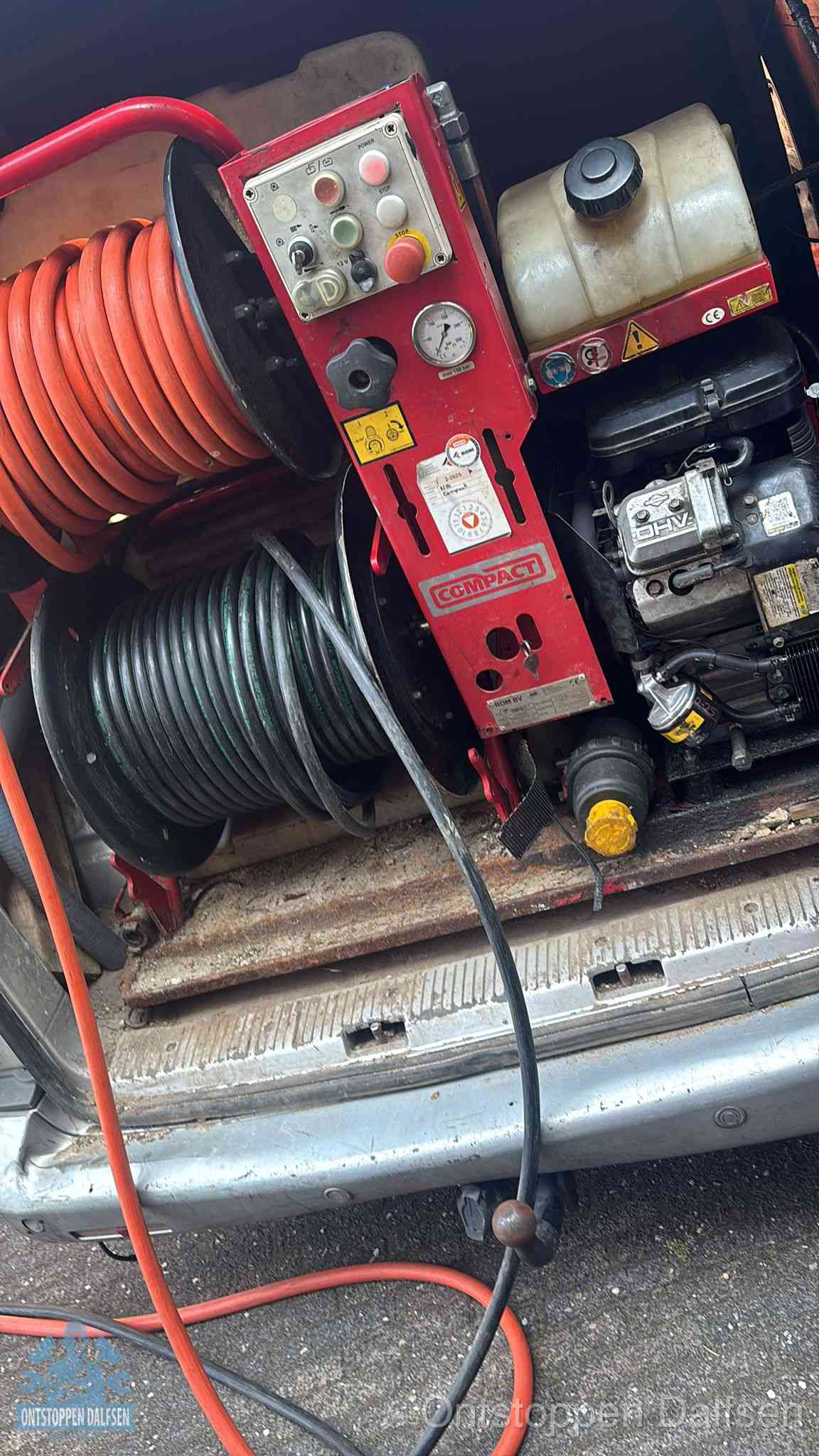 Een rood hogedruk-rioolreinigingstoestel met slangen in de laadbak van de bedrijfsbus, apparatuur voor een hardnekkige wc-verstopping in Dalfsen