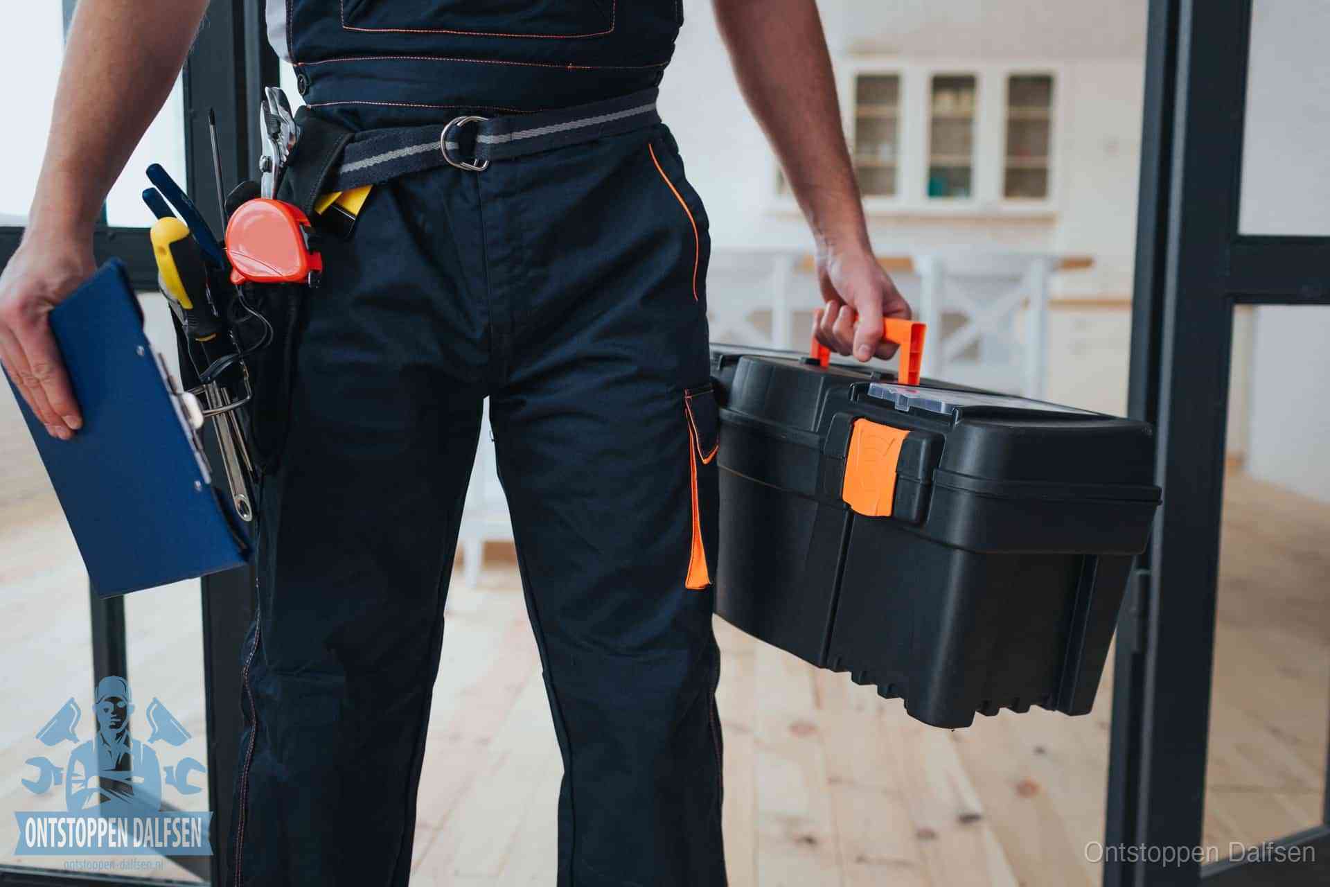 Een monteur met gereedschapsriem en klembord in een keuken, klaar om een transparante prijs voor het gootsteen ontstoppen in Dalfsen te geven