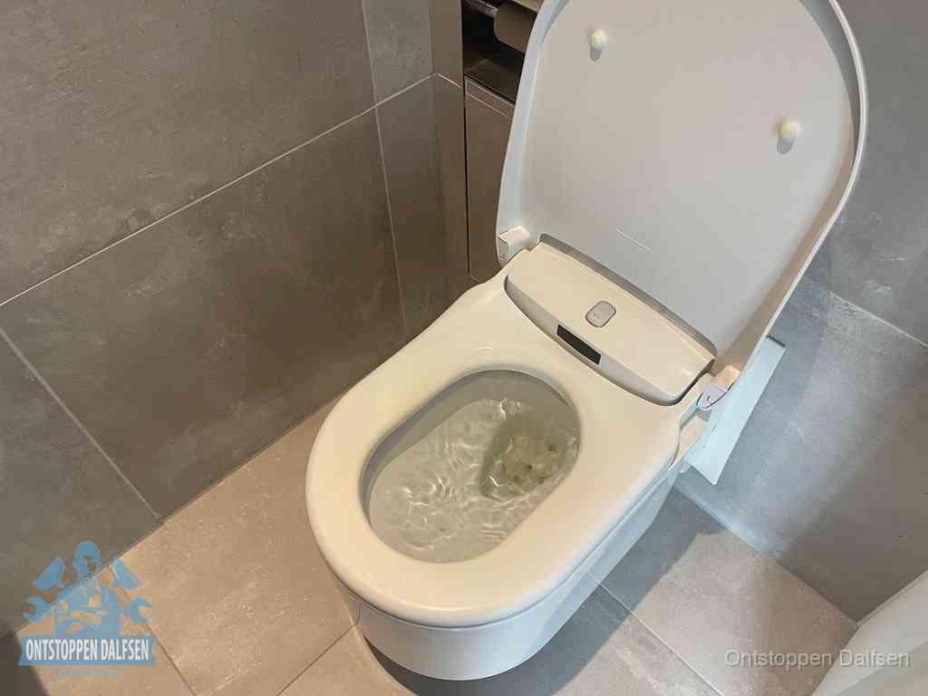 Een toiletpot vol troebel water met drijvend papier en restanten, de meest voorkomende oorzaak van een verstopte wc in Dalfsen