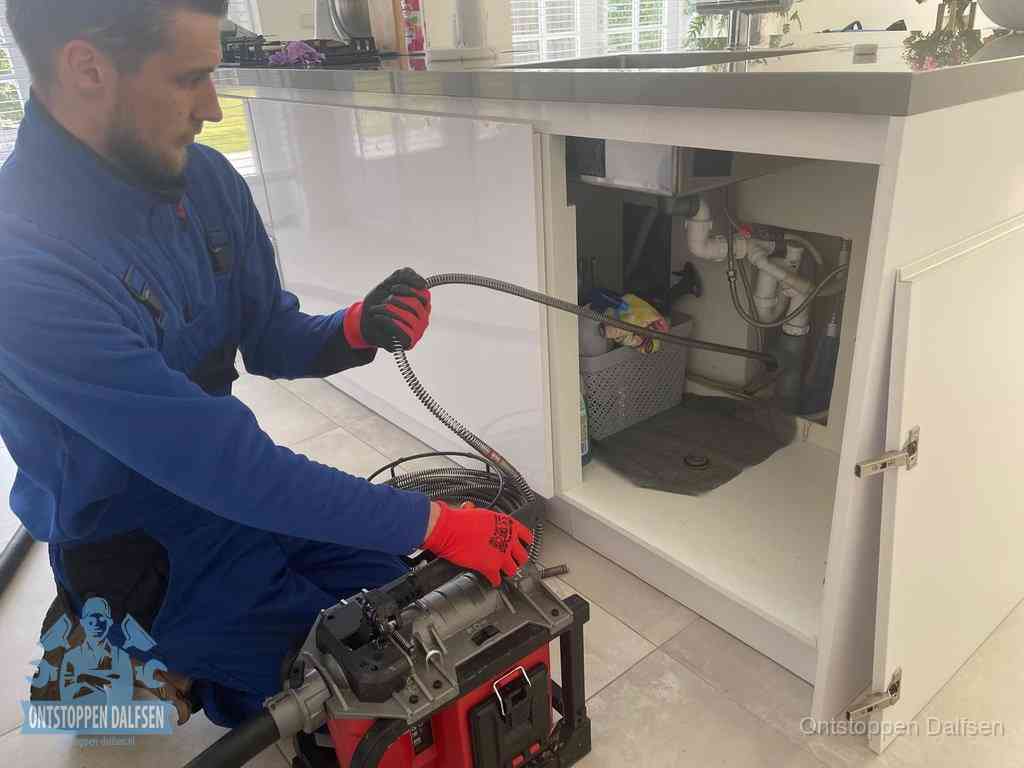 Een monteur reinigt de keukenafvoer grondig met een veermachine om terugkerende gootsteenverstoppingen te voorkomen in Dalfsen